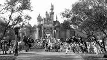 Children sprint across a drawbridge and into the castle that marks the entrance to Fantasyland at the opening of Walt Disney's Disneyland.
