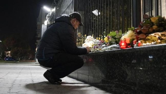 A man lights a candle to pay tribute to victims of the Russian plane crash at the Russian Embassy in Kiev (AP)