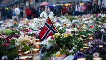 Norwegian flags, flowers and candles commemorating the victims of the attacks are seen at the ground in front of the Domkirke church in central Oslo.