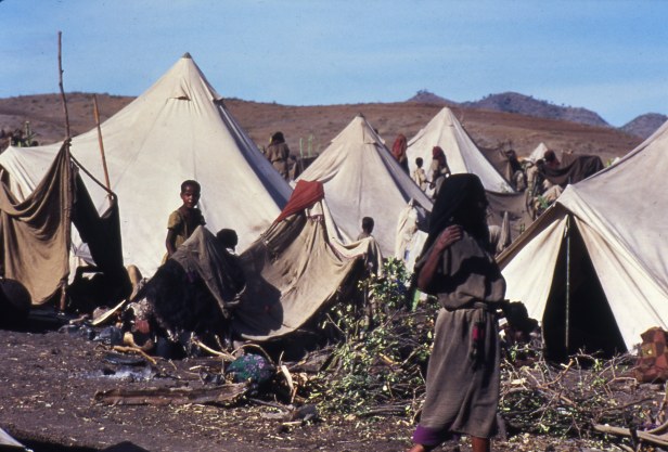 Ethiopian famine victims stand at their tents at the refugee camp camp in Bati.
