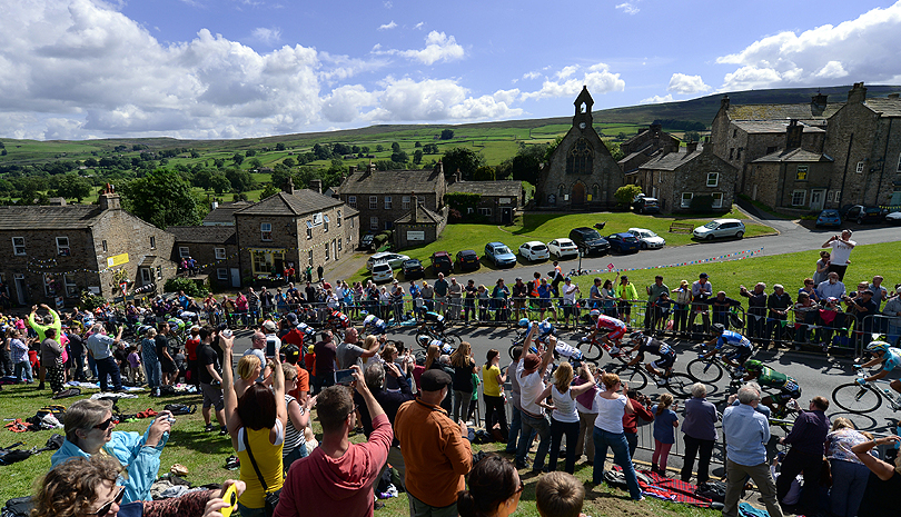 Thousands watch as stage one of the Tour de France passes through the village of Reeth